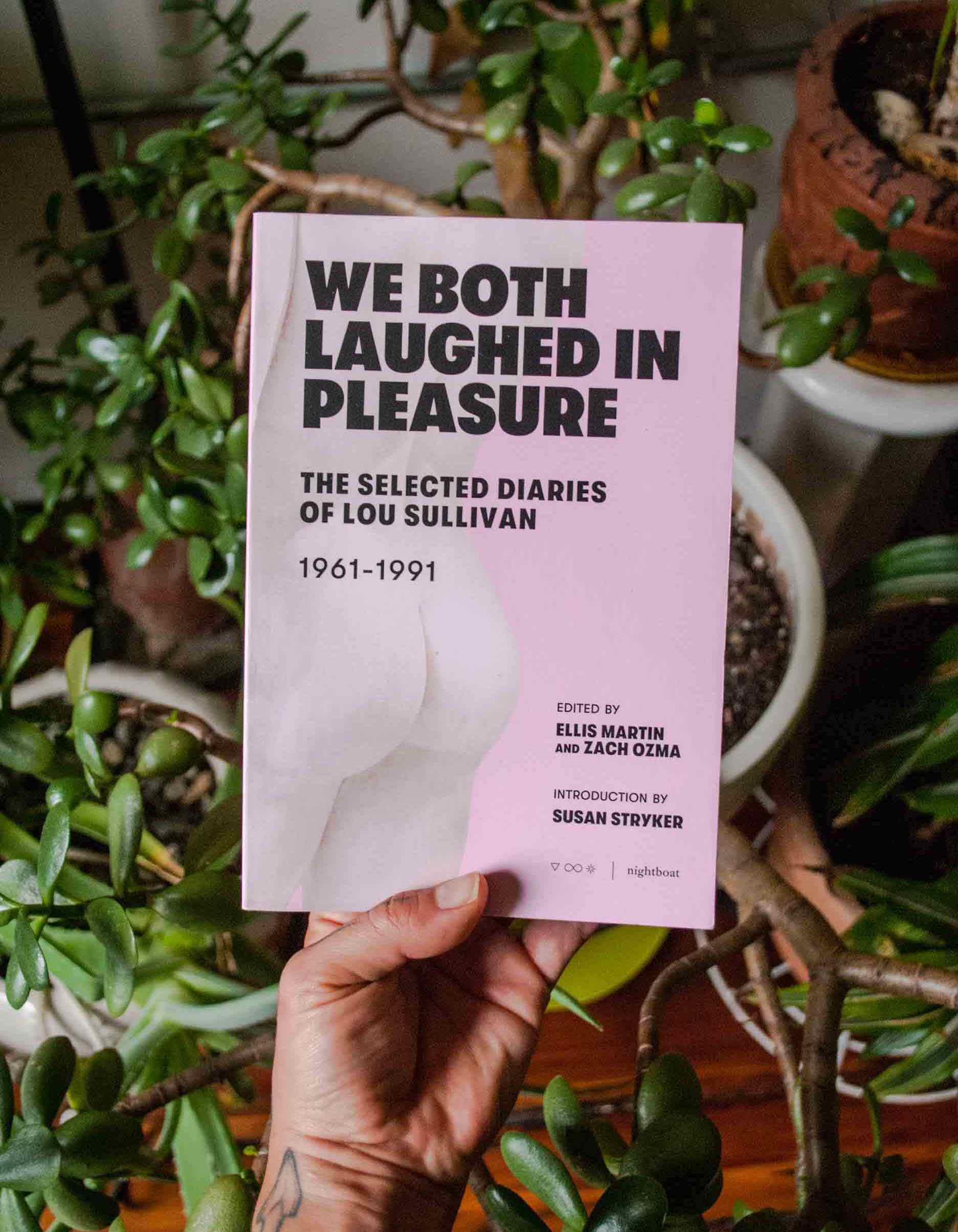 I'm holding the book with its pink cover over a sprawling jade plant in my room