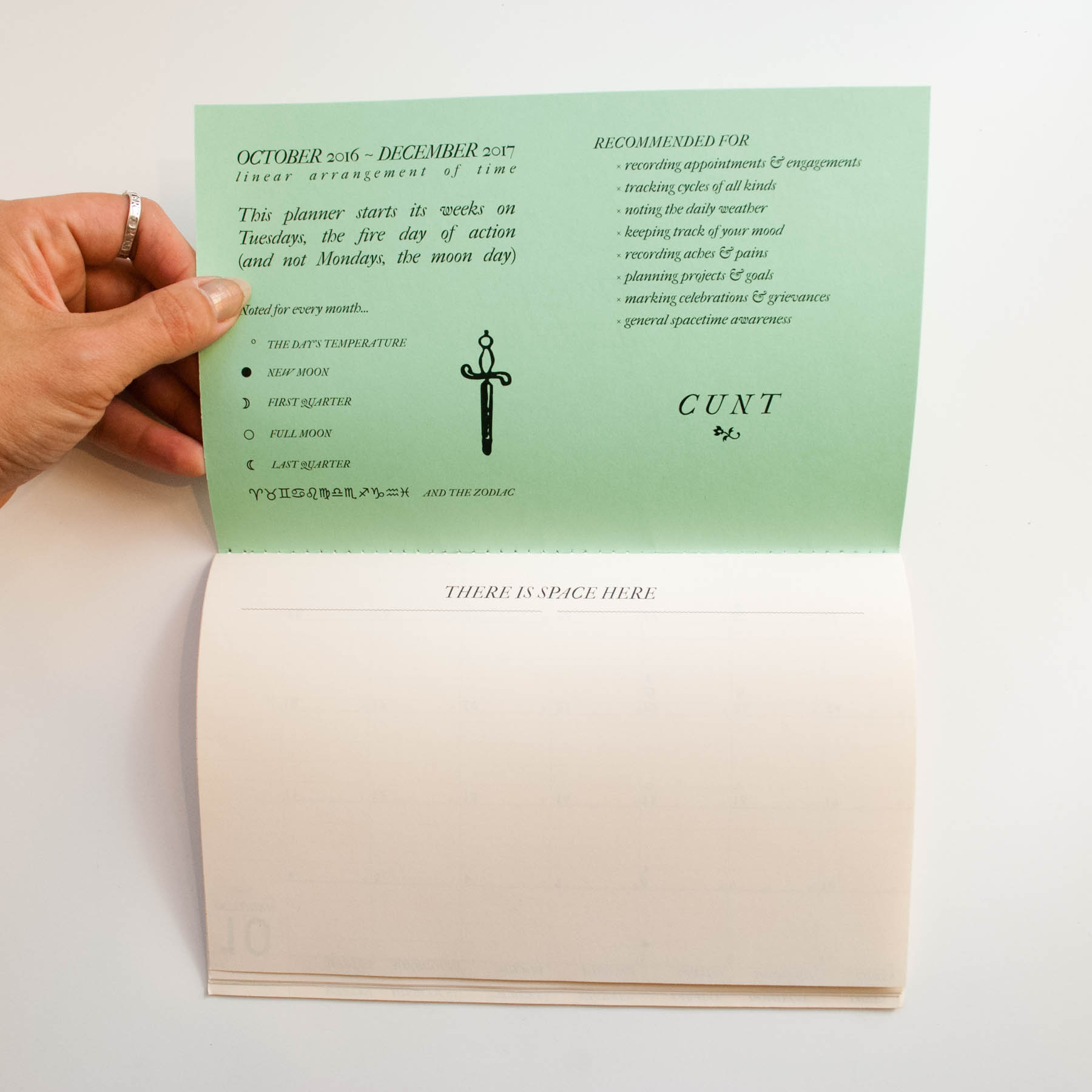 hand holds open front cover of planner